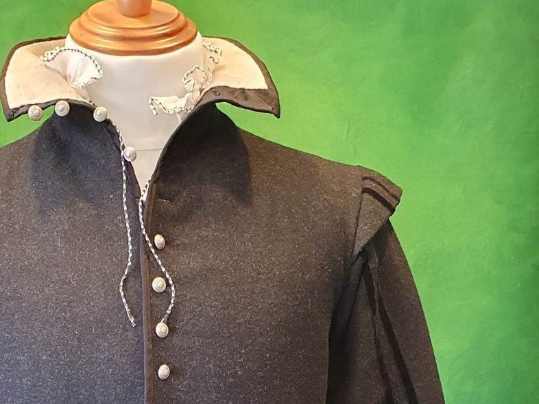 Top of a dark grey doublet with pewter buttons on a mannequin