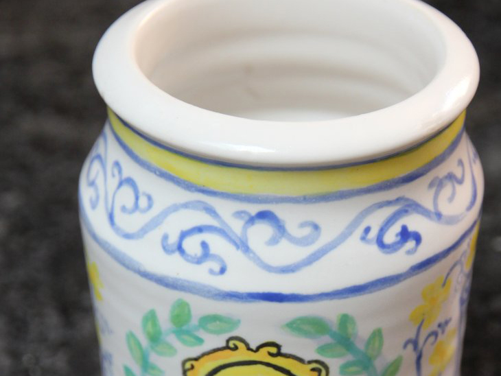 Top of ceramic jar with painted scrolling decoration around the rim