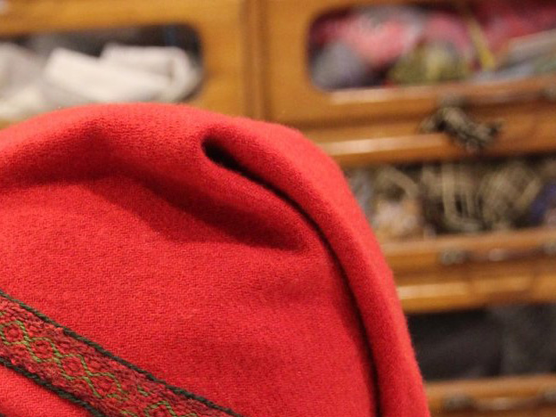 Part of a soft hat in red wool, with the top point flopped over