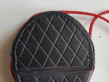 Top of a leather case with incised cross-hatch decoration and silk cord