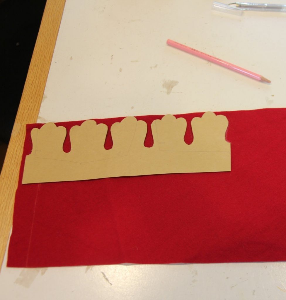 Cardboard template for edge dags lying on red wool
