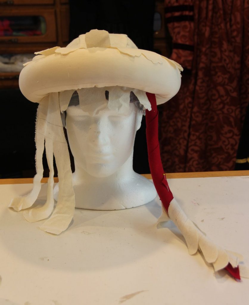 Headform with stuffed roll, mantle and liripipe made of scrap fabric