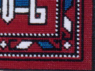 Corner of a carpet, with a graphic design in red, blue and white