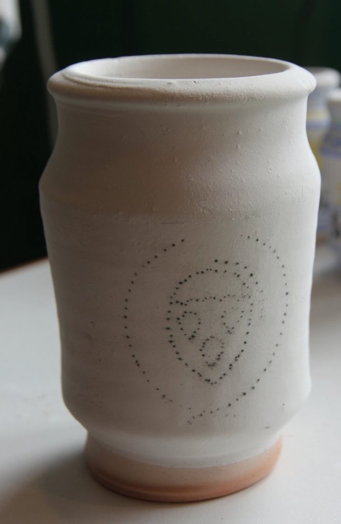 White ceramic pot with design drawn on