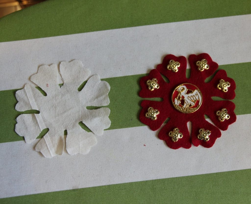 Pattern lying next to finished rosette, with badge and gold decorations