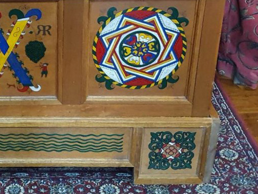 Part of a wooden chest with bright painted decoration