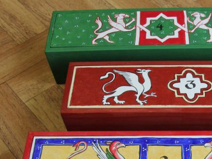 Part of three small wooden boxes, painted in medieval style with griffins