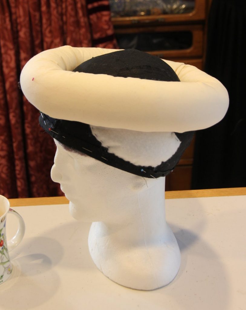 Headform wearing cap liner and stuffed roll on top