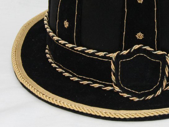 Part of hat in black velvet, with a narrow brim decorated with gold trim,