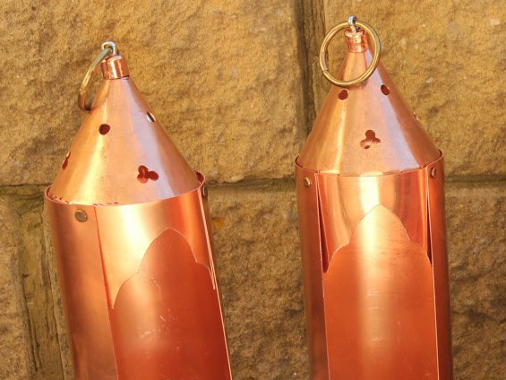 A pair of copper lanterns, with pierced conical lids and ring handles