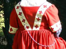 Man's torso, viewed from the back, wearing a 16th century German gown with pleated skirt