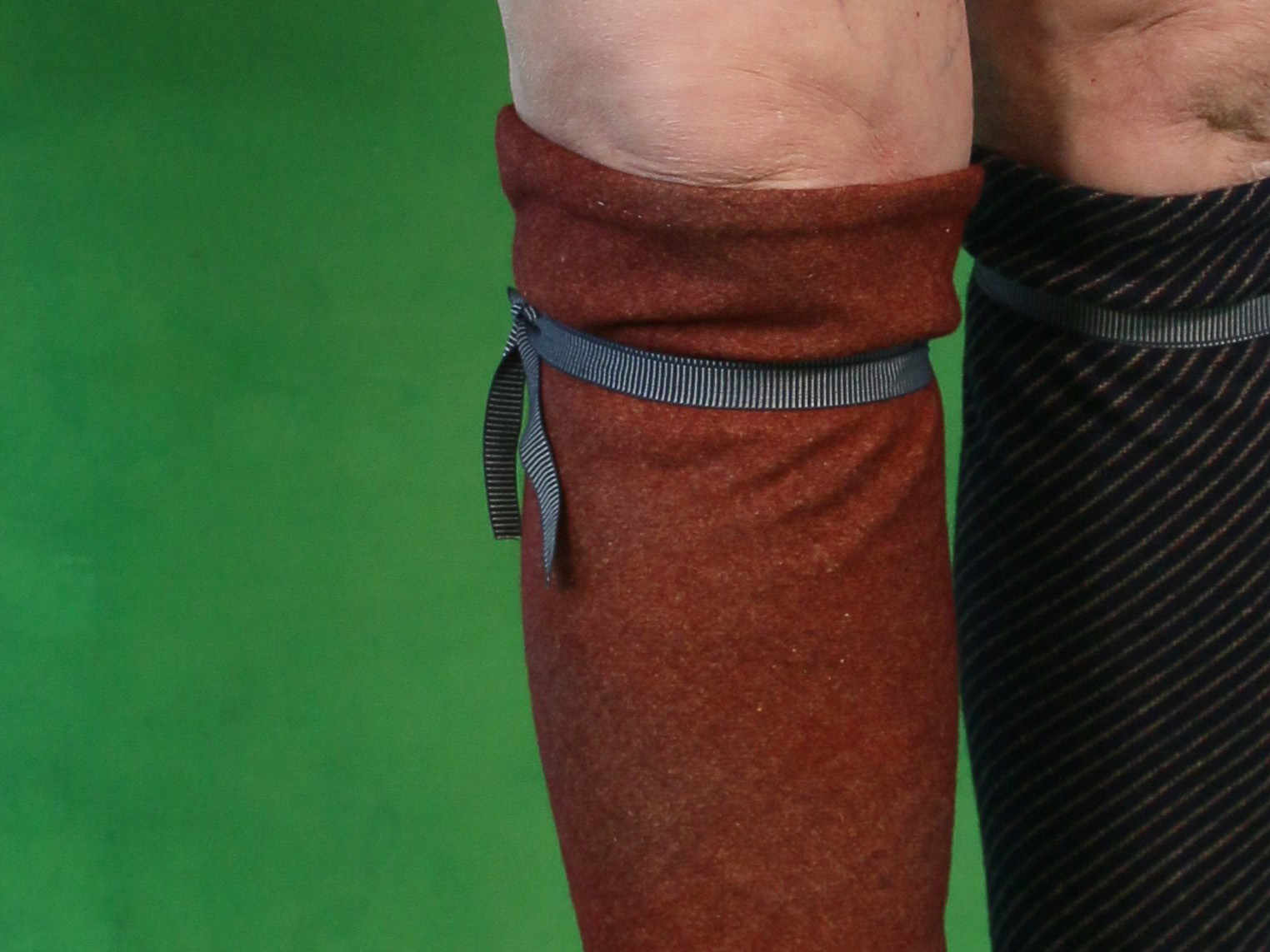 Legs with knee-length woollen hose, held up with tied garters under the knees