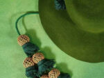 Corner of a felt hat with a cord ending in many tassels